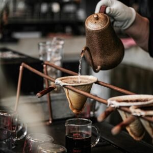 Close-up of artisan coffee brewing using a pour over method with kettle and ceramic dripper.