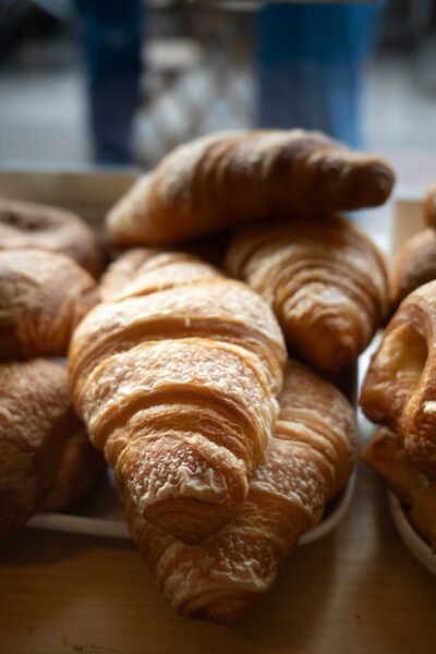 Fresh croissants in a bakery, perfect example of French pastry. Captured indoors under soft lighting.