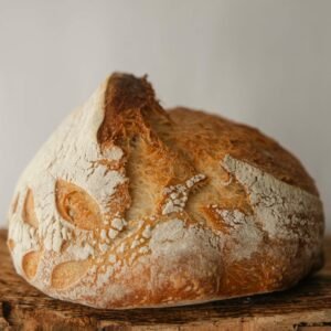 Close-up of freshly baked artisan sourdough bread on a rustic wooden board.